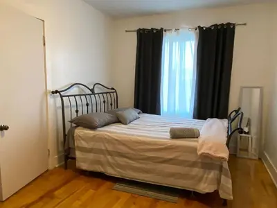 a bed in a room with a large window at Chambre supérieure, ensoleillée et spacieuse in Montréal