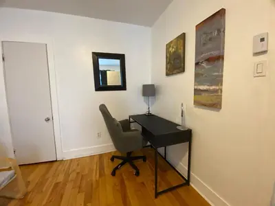 a room with a desk with a chair and a lamp at Chambre supérieure, ensoleillée et spacieuse in Montréal