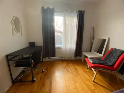a room with a desk and a chair and a mirror at Chambre supérieure, ensoleillée et spacieuse in Montréal