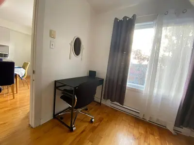 a black desk in a room with a window at Chambre supérieure, ensoleillée et spacieuse in Montréal