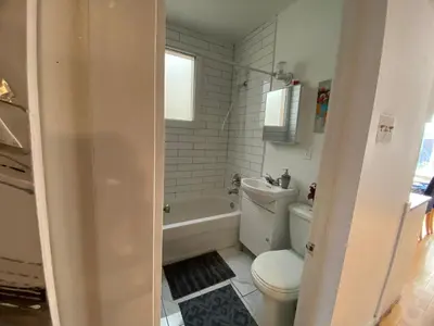 a bathroom with a toilet and a tub and a sink at Chambre supérieure, ensoleillée et spacieuse in Montréal