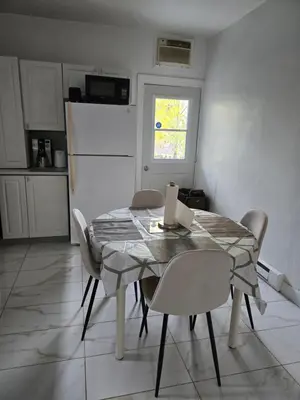 a kitchen with a table with chairs and a refrigerator at Spacious, elegant, and ultra-comfortable room in Montréal