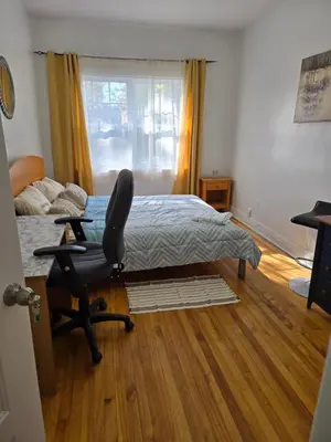a bedroom with a bed and a chair and a window at Spacious, elegant, and ultra-comfortable room in Montréal