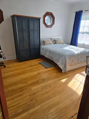 a bedroom with a bed and a wooden floor at Spacious, elegant, and ultra-comfortable room in Montréal
