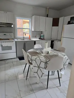 a kitchen with a table and chairs and a sink at Spacious, elegant, and ultra-comfortable room in Montréal