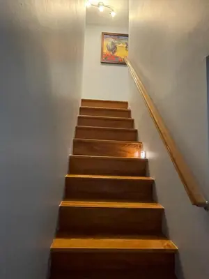 a staircase with wooden steps and a painting on the wall at La Maison 4 Saisons, chambre-Hiver in Saint-Jean-sur-Richelieu