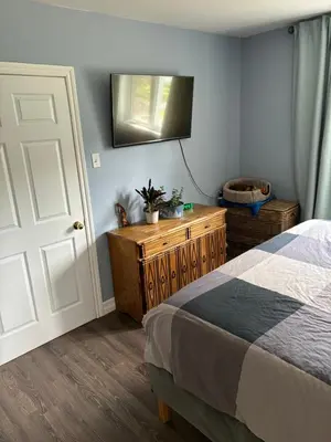 a bedroom with a bed and a television on the wall at La Maison 4 Saisons, chambre-Hiver in Saint-Jean-sur-Richelieu
