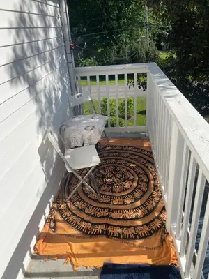 a chair sitting on a rug on a porch at La Maison 4 Saisons, chambre-Hiver in Saint-Jean-sur-Richelieu