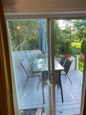 a sliding glass door to a patio with a table and chairs at La Maison 4 Saisons, chambre-Hiver in Saint-Jean-sur-Richelieu