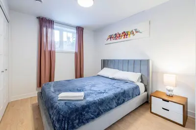 a bedroom with a blue bed and a window at T3 10 mins to La Ronde nice , Cozy 3 bedroom longueuil in Longueuil