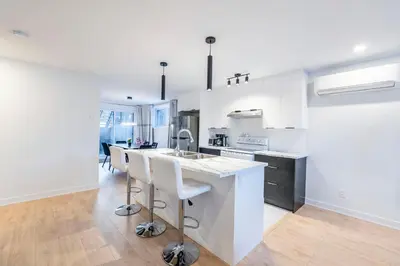 a white kitchen with a sink and a counter at T3 10 mins to La Ronde nice , Cozy 3 bedroom longueuil in Longueuil