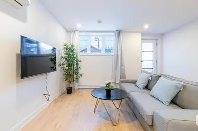a living room with a couch and a table at T3 10 mins to La Ronde nice , Cozy 3 bedroom longueuil in Longueuil