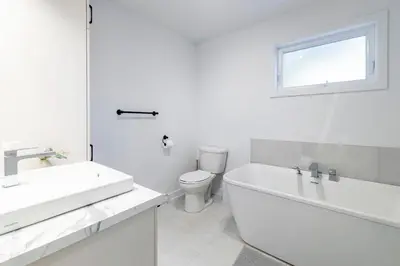 a white bathroom with a sink and a toilet at T3 10 mins to La Ronde nice , Cozy 3 bedroom longueuil in Longueuil