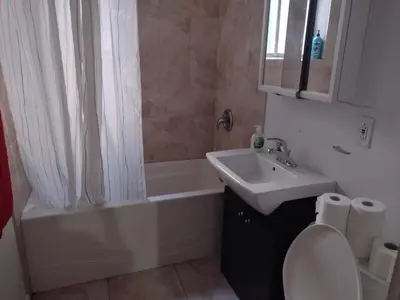 a bathroom with a sink and a tub and a toilet at Antic Style with high ceiling in Montréal