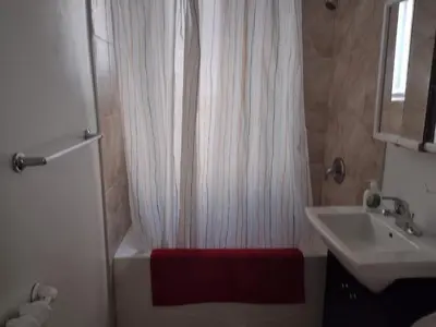 a bathroom with a white shower curtain and a sink at Antic Style with high ceiling in Montréal