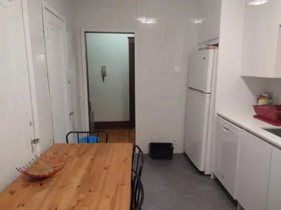 a kitchen with a wooden table and a white refrigerator at Antic Style with high ceiling in Montréal