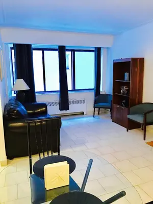 a living room with a couch and chairs and windows at Stylish Montreal Apartment Comfortable Stay in the Golden Square Mile in Montréal