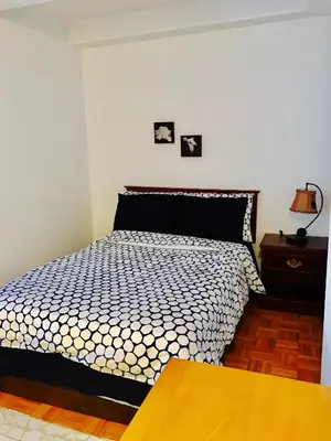 a bedroom with a black and white bed and a table at Stylish Montreal Apartment Comfortable Stay in the Golden Square Mile in Montréal
