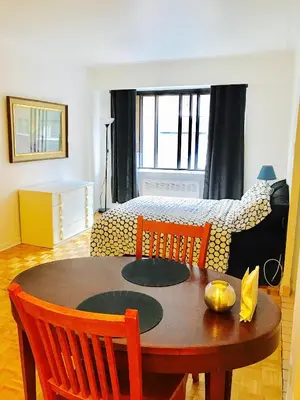 a living room with a table and a bed at Stylish Montreal Apartment Comfortable Stay in the Golden Square Mile in Montréal