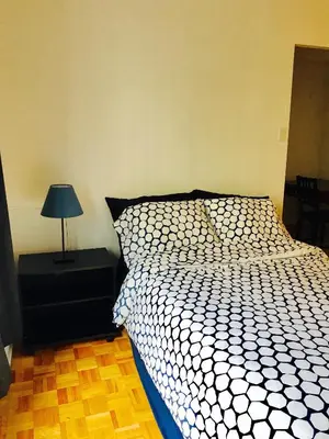 a bedroom with a bed and a lamp on a night stand at Stylish Montreal Apartment Comfortable Stay in the Golden Square Mile in Montréal