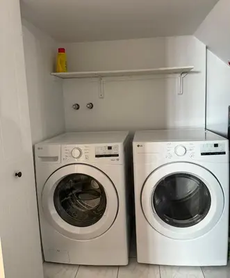 a laundry room with a washing machine and a washer at Charmant appartement au sous-sol in Longueuil