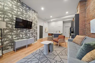 a living room with a couch and a tv on a wall at The Ontario Loft Suites in Montréal