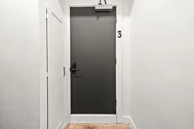 a door in a white room with a black door at The Ontario Loft Suites in Montréal
