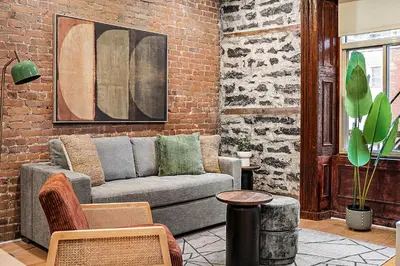 a living room with a couch and a brick wall at The Ontario Loft Suites in Montréal