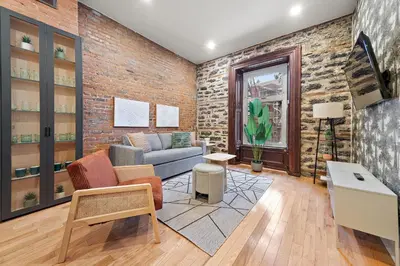 a living room with a couch and a brick wall at The Ontario Loft Suites in Montréal