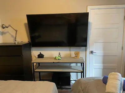 a large flat screen tv on a wall with a table at cozy apartment in the heart of downtown Montreal in Montréal