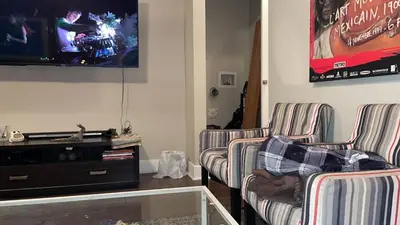 a living room with two chairs and a flat screen tv at cozy apartment in the heart of downtown Montreal in Montréal