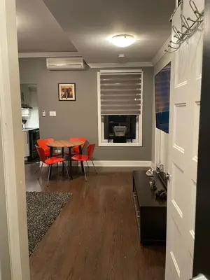 a living room with a table and red chairs at cozy apartment in the heart of downtown Montreal in Montréal