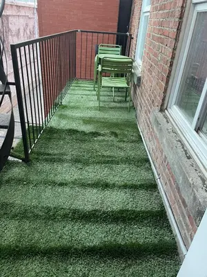 a balcony with two chairs and a fence at cozy apartment in the heart of downtown Montreal in Montréal