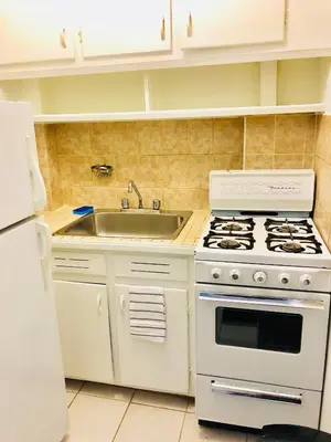 a kitchen with a white stove and a sink at Stylish Montreal Apartment Comfortable Stay in the Golden Square Mile in Montréal