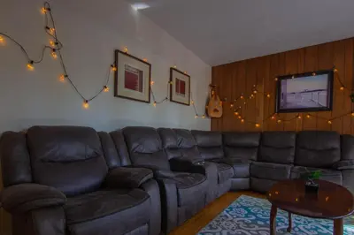 a living room with a leather couch and a table at Maison cosy - 6p - Proche de Centropolis & Carrefour Laval in Laval