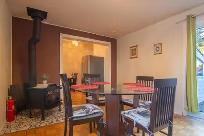 a dining room with a table and chairs and a stove at Maison cosy - 6p - Proche de Centropolis & Carrefour Laval in Laval