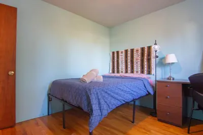 a bedroom with a bed with a purple blanket and a dresser at Maison cosy - 6p - Proche de Centropolis & Carrefour Laval in Laval