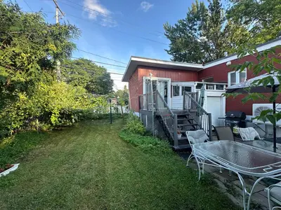 a house with a patio with a table and chairs at Maison cosy - 6p - Proche de Centropolis & Carrefour Laval in Laval