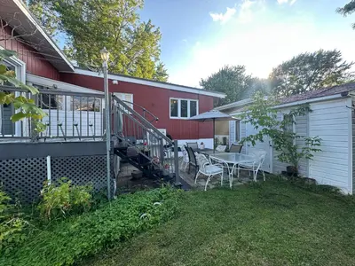 a house with a table and chairs in the yard at Maison cosy - 6p - Proche de Centropolis & Carrefour Laval in Laval