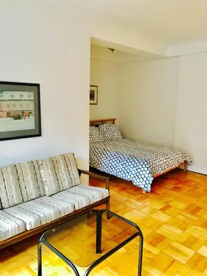 a living room with a couch and a bed at Stylish Montreal Apartment Comfortable Stay in the Golden Square Mile in Montréal