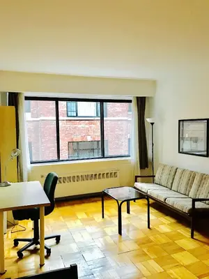a living room with a couch and a table at Stylish Montreal Apartment Comfortable Stay in the Golden Square Mile in Montréal