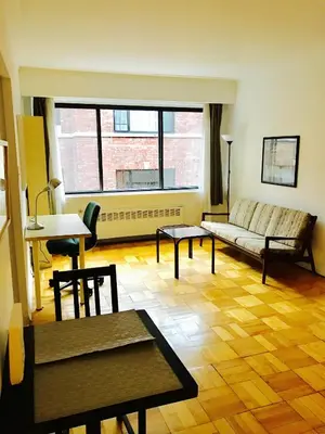 a living room with a couch and a table at Stylish Montreal Apartment Comfortable Stay in the Golden Square Mile in Montréal