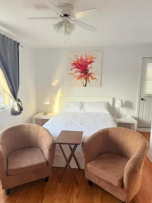 a bedroom with a bed and two chairs at Cozy & spacious 3 BDR condo in Montréal