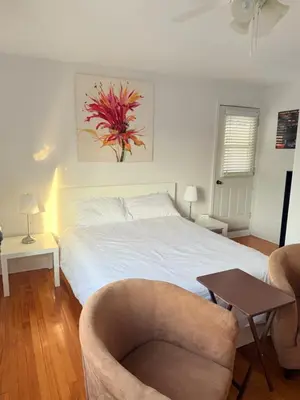 a bedroom with a bed and a chair and a table at Cozy & spacious 3 BDR condo in Montréal