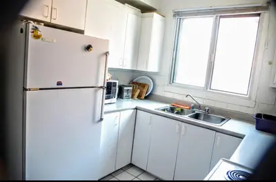 a kitchen with a white refrigerator and a sink at Appartement chic in Montréal