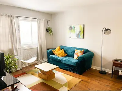 a living room with a blue couch and a table at Comodo apartamento tipo estudio in Montréal
