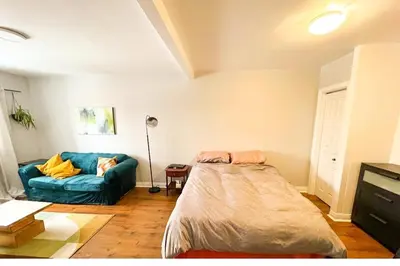 a bedroom with a blue bed and a couch at Comodo apartamento tipo estudio in Montréal