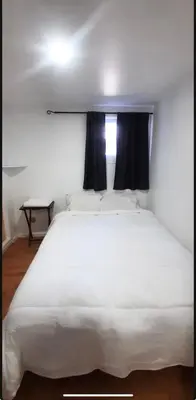 a large white bed in a room with a window at Cute 2 BDR condo in Montréal