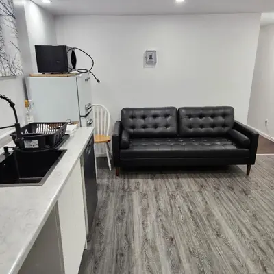 a black leather couch in a living room at Cute 2 BDR condo in Montréal