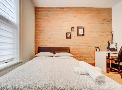 a bed in a room with a brick wall at Great 3B unit on Saint-Urbain in Montréal